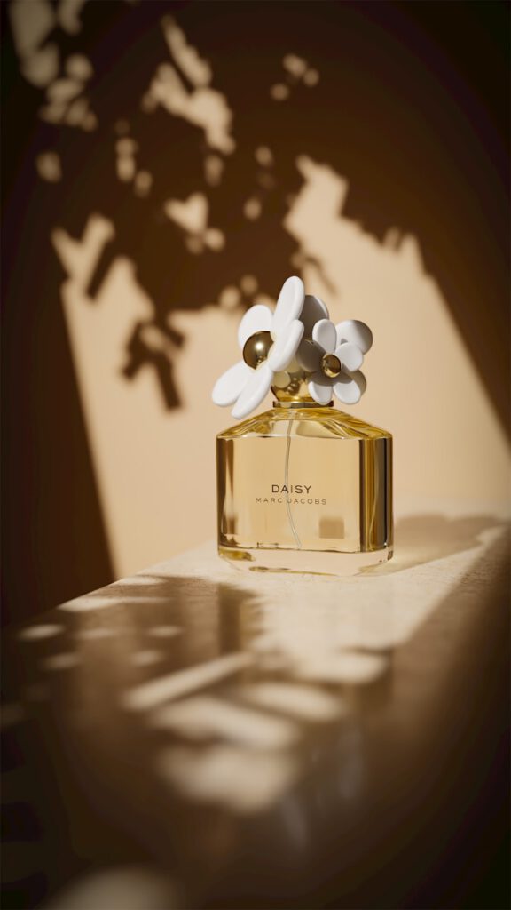 A bottle of daisy perfume with floral accents.